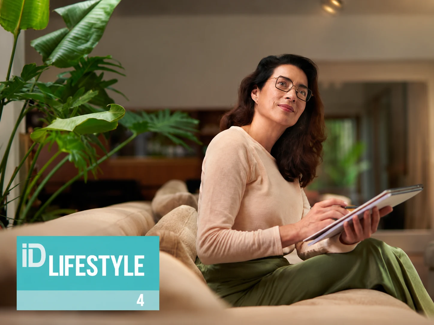تصویر رسمی LifeStyle 4 هویا؛ زن عینکی هنگام نوشتن روی مبل، همراه نشان مدل در پایین چپ